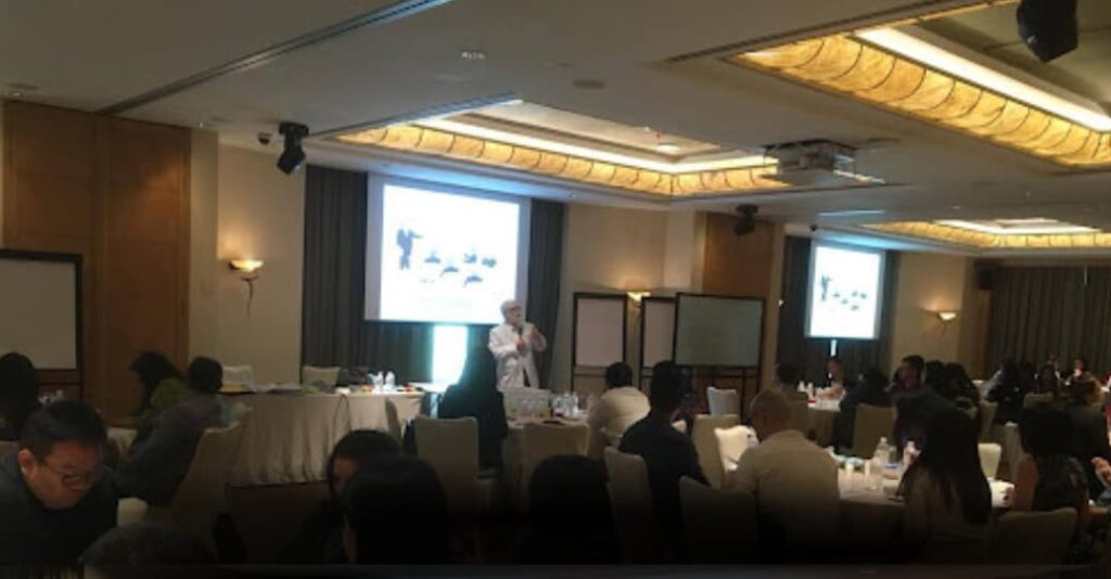 Speaker presenting to an audience during a conference seminar.