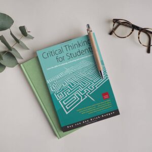 Book titled "Critical Thinking for Students" by Roy van den Brink-Budgen placed on a desk with a pen and glasses.