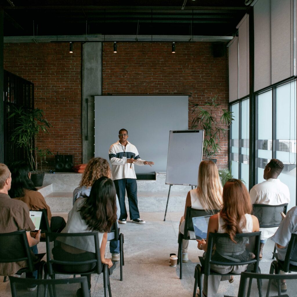 Critical thinking trainer leading a workshop with attendees in a modern training room.